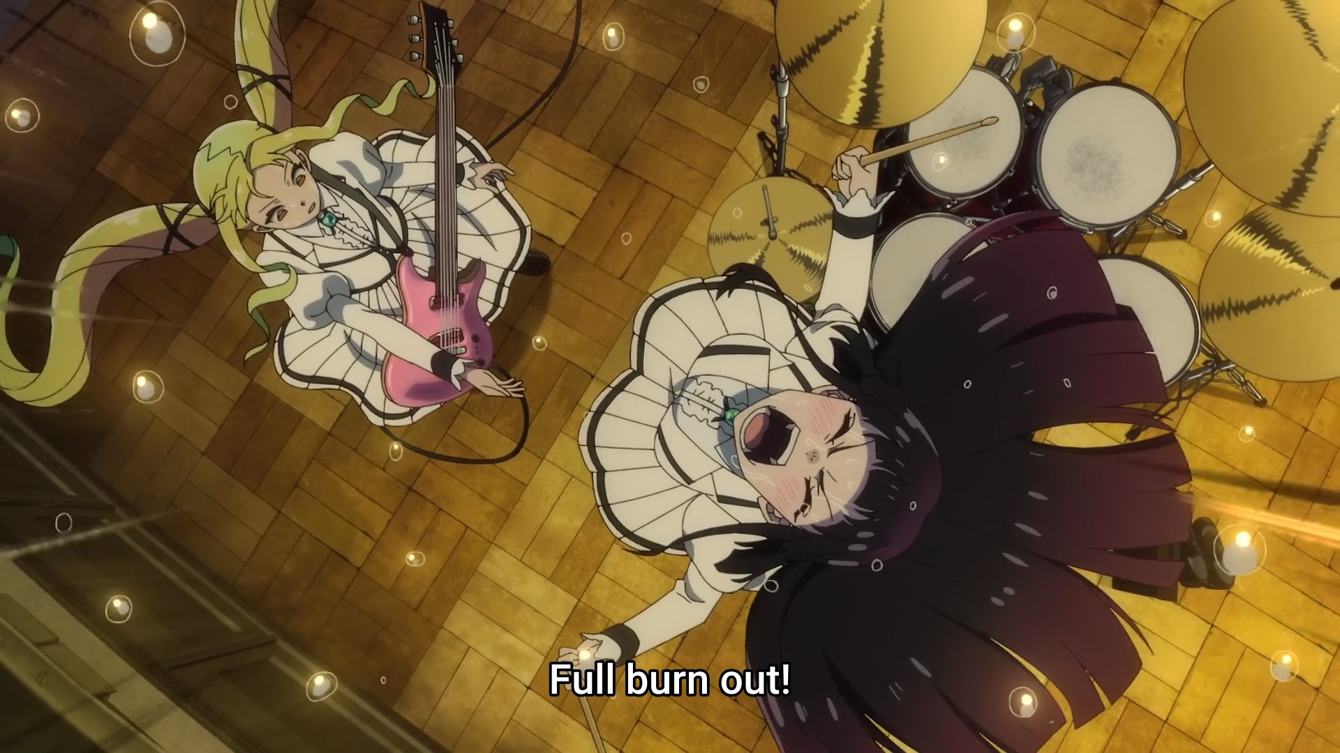 Otoha jumps into the air from behind her drum kit, eyes closed, drum sticks in hand, shouting 'full burn out!' at a stunned Lilisa, guitar around her neck, holding out her hand to shake Otoha's.